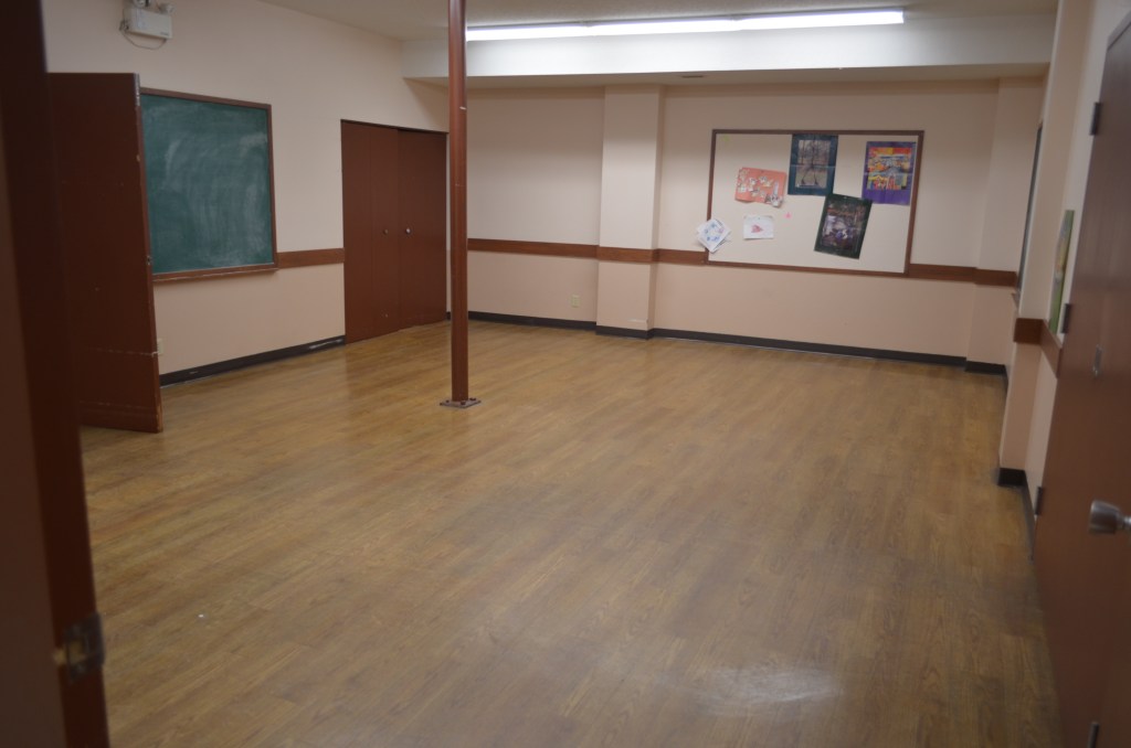 Meeting room with laminate flooring and chalkboard.