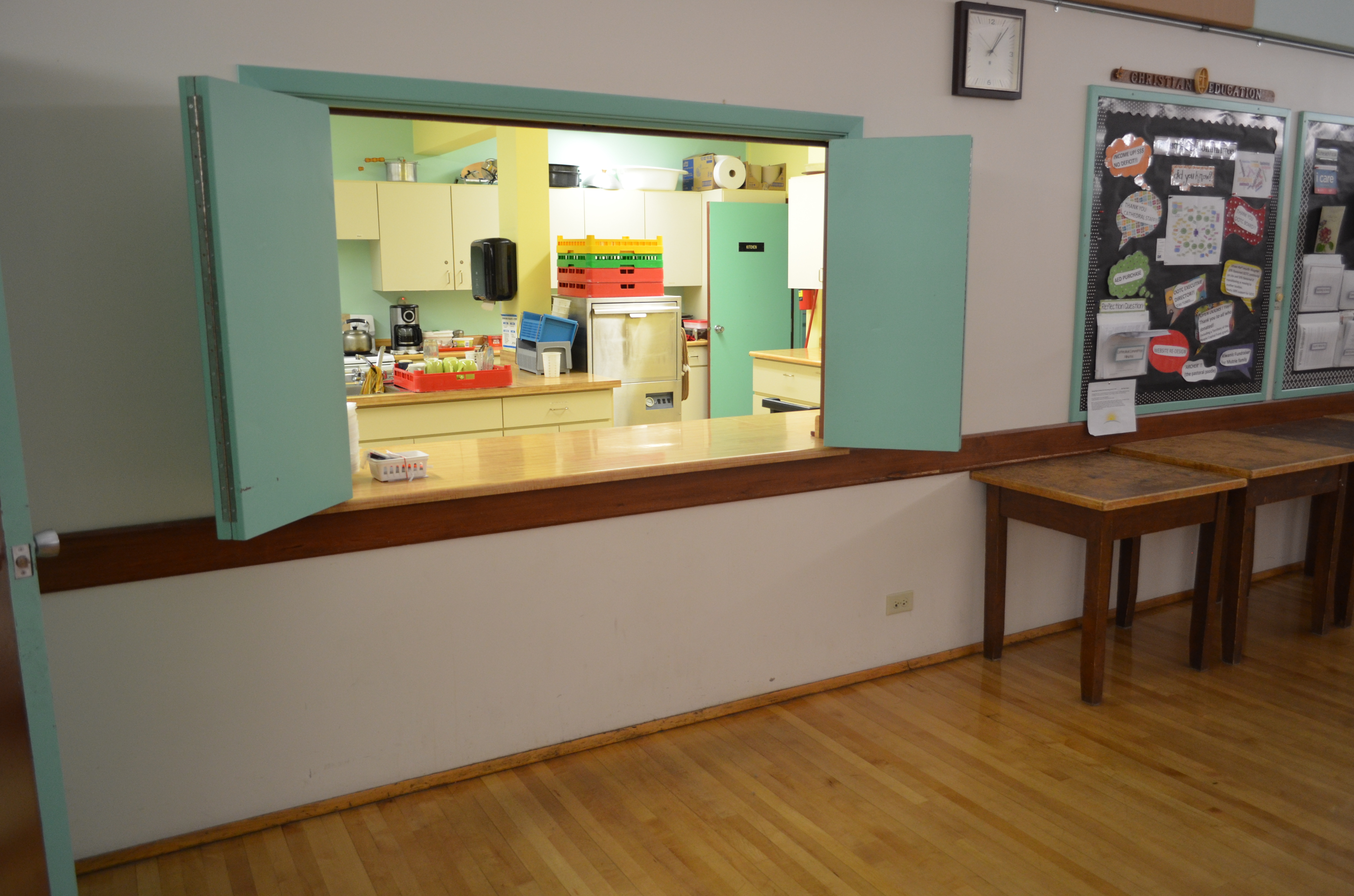 Opening in wall with counter leading to kitchen. Doors that can be open or shut to the kitchen.